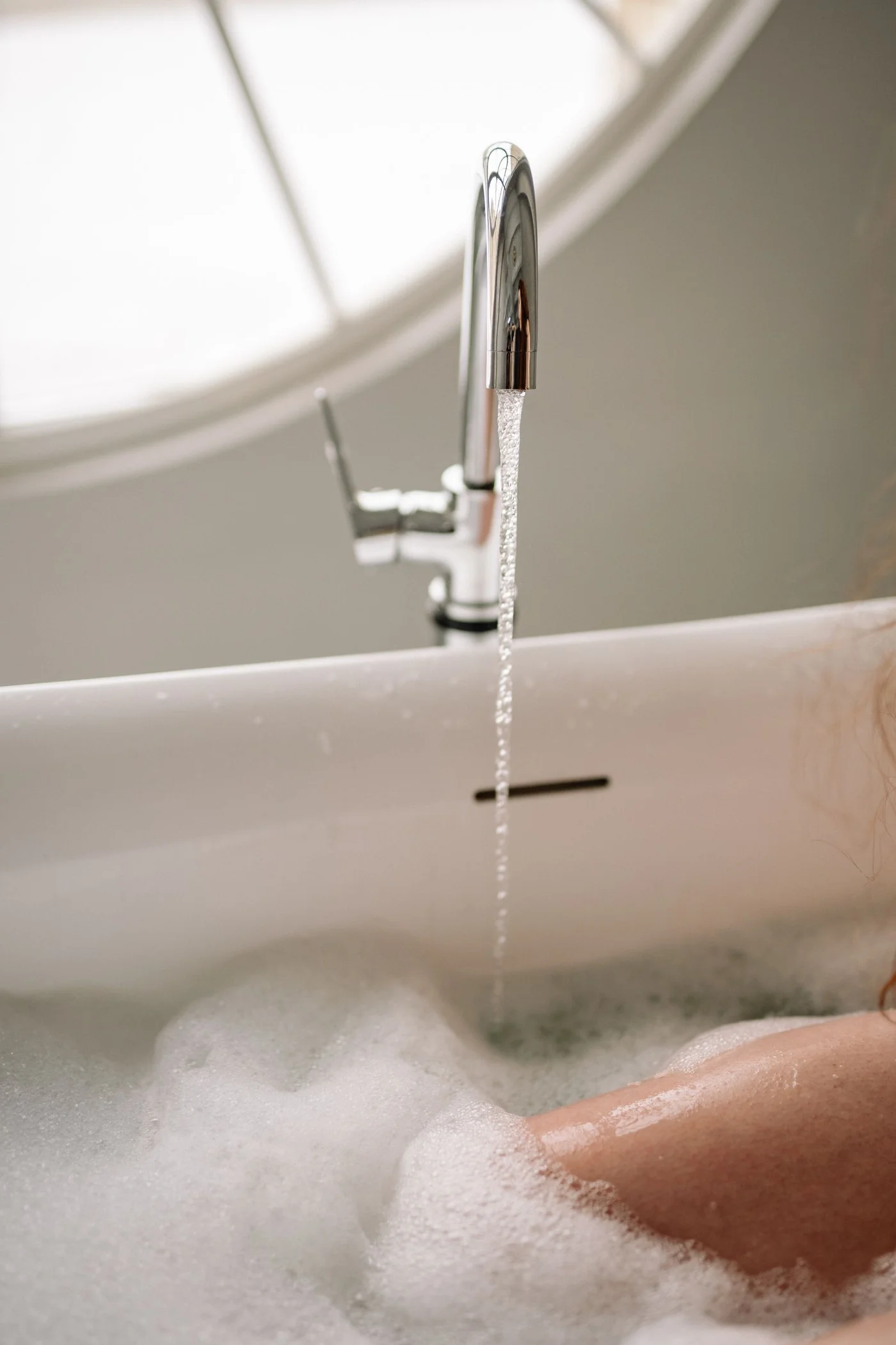 Water flowing into a bubble-filled hydrotherapy bath